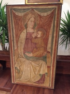 La tela della Madonna della Pietra si trova a Cagnola. Un falegname è al lavoro per collocarla nell'abside della chiesa millenaria (Foto Redacon - G. Arlotti)